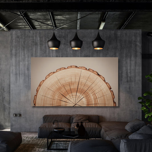 a modern living room with a large, abstract painting of a tree trunk as the focal point. The room has a minimalist design with a gray sofa, a coffee table, and a potted plant. The ceiling features three black pendant lights, creating a warm and inviting atmosphere.
