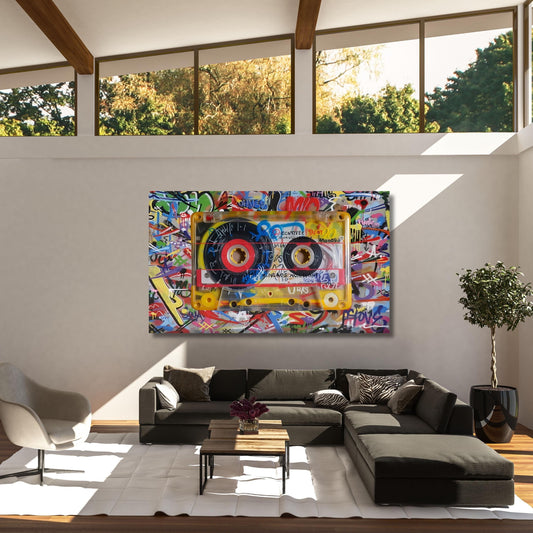 May include: A large canvas art piece featuring a yellow cassette tape design with colorful graffiti art. The cassette tape has red and black details. The background is a vibrant mix of graffiti art in various colors.